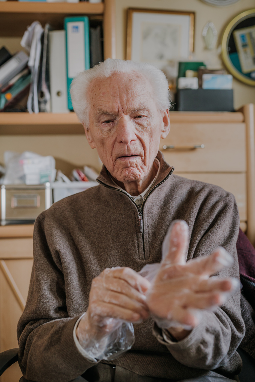 Elderly man wearing hygiene gloves.