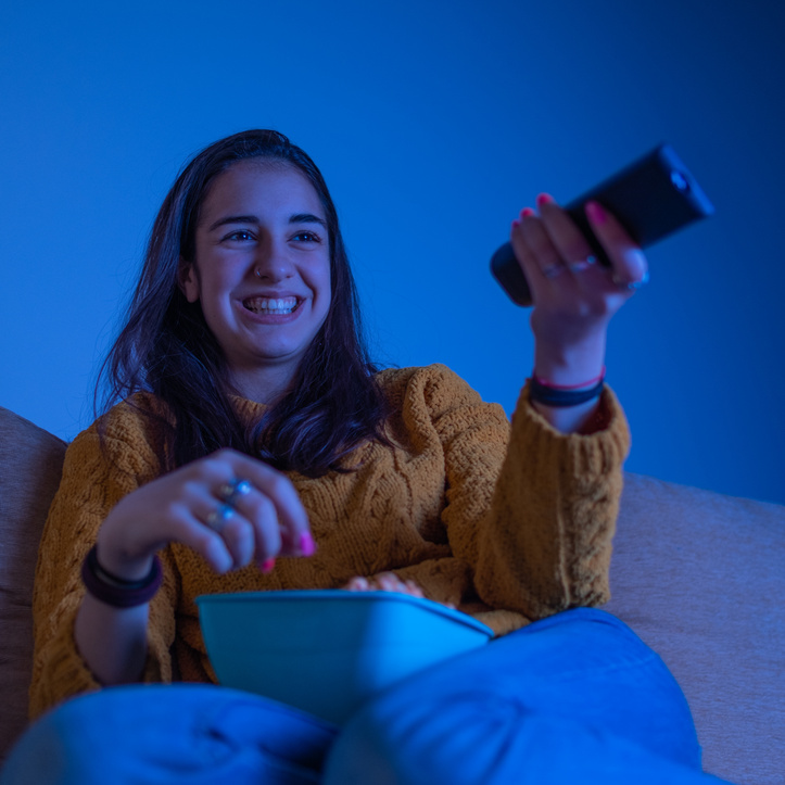 Beautiful young attractive girl smiling and watching movie