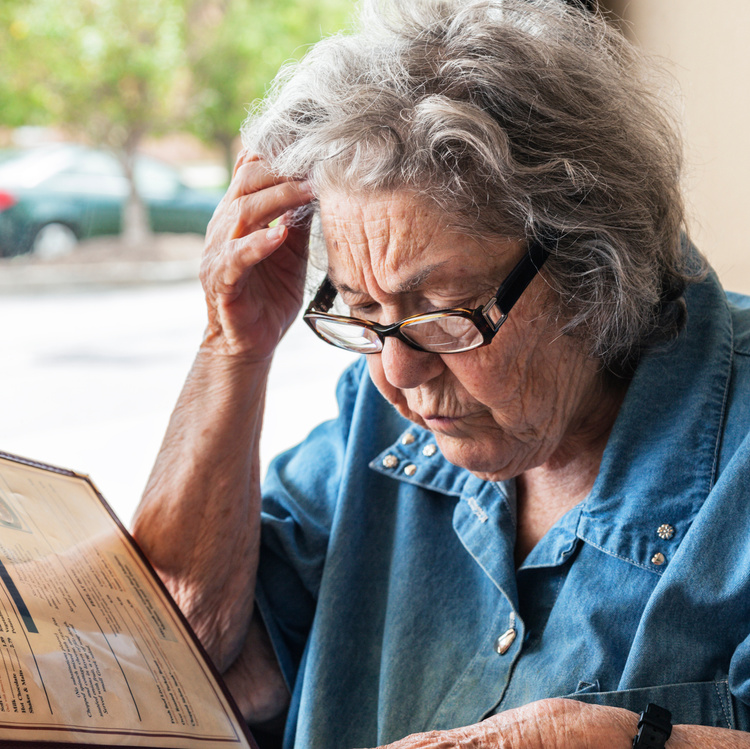 Elderly Woman With Dementia Reading Restaurant Menu